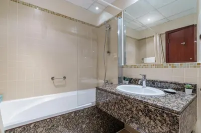 a bathroom with a sink and a shower and a tub at GuestReady - Lux Aeterna in JBR in Dubai