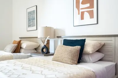 a bedroom with a bed and a couch with pillows at GuestReady - Lux Aeterna in JBR in Dubai