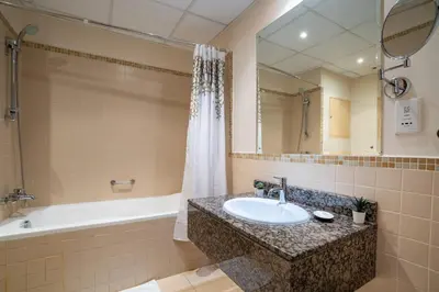 a bathroom with a sink and a tub and a mirror at GuestReady - Lux Aeterna in JBR in Dubai