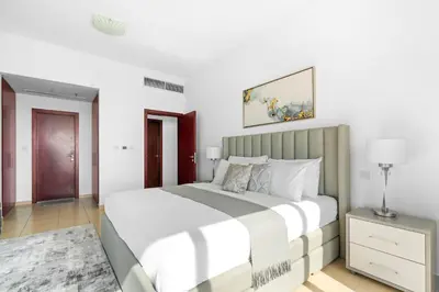 a white bedroom with a large bed and a table at Beautiful Sea and Marina View - Premium 2BR in JBR in Dubai
