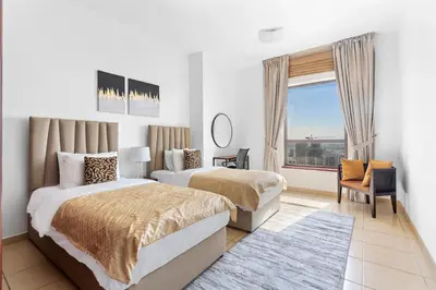 a hotel room with two beds and a window at Beautiful Sea and Marina View - Premium 2BR in JBR in Dubai
