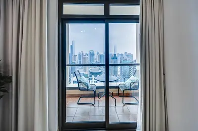 a room with a large window with a table and chairs at Spacious 2BD in Amwaj JBR near the beach in Dubai