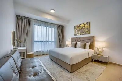 a bedroom with a large bed and a couch at Spacious 2BD in Amwaj JBR near the beach in Dubai