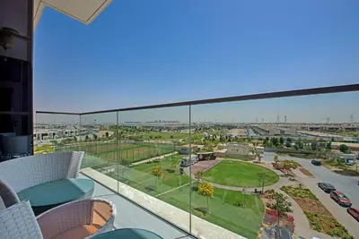 a view of a city from the balcony of a building at Bright and spacious apartment in DAMAC HILLS in Dubai