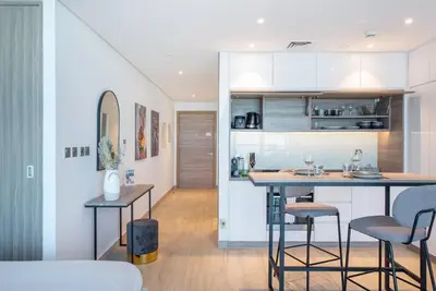 a kitchen and living room with a counter and chairs at Funky STUDIO Dubai Marina outstanding facilities in Dubai