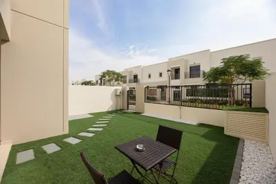 a patio with a table and chairs in a yard at Stunning 4 bedroom townhouse in Townsquare in Dubai