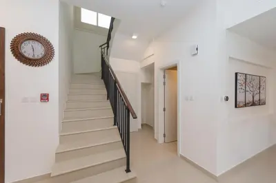 a staircase in a house with white walls and a window at Stunning 4 bedroom townhouse in Townsquare in Dubai
