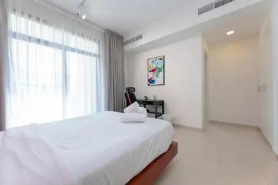 a white bedroom with a large bed and a window at Stunning 4 bedroom townhouse in Townsquare in Dubai