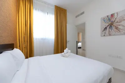 a bedroom with a white bed and a window at Stunning 4 bedroom townhouse in Townsquare in Dubai