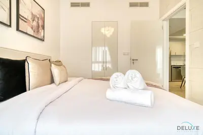 a bedroom with a bed with white towels on it at Serene 2BR at The Nook Wasl Gate Jebel Ali by Deluxe Holiday Homes in Dubai