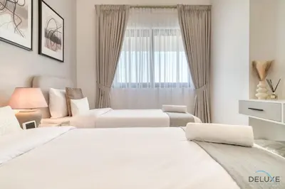 two white beds in a room with a window at Serene 2BR at The Nook Wasl Gate Jebel Ali by Deluxe Holiday Homes in Dubai
