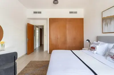 a bedroom with a large white bed with a wooden headboard at Frank Porter - Al Sidir 2 in Dubai