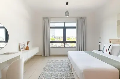 a white bedroom with a large bed and a window at Frank Porter - Al Sidir 2 in Dubai