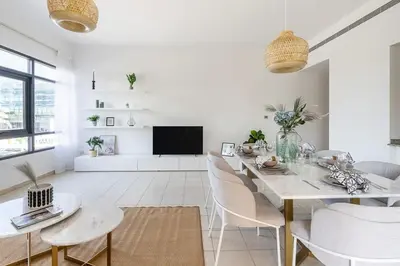 a white living room with a table and chairs at Frank Porter - Al Sidir 2 in Dubai