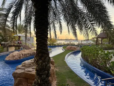 a palm tree in the middle of a swimming pool at Sunset view apartment in Oceana in Dubai