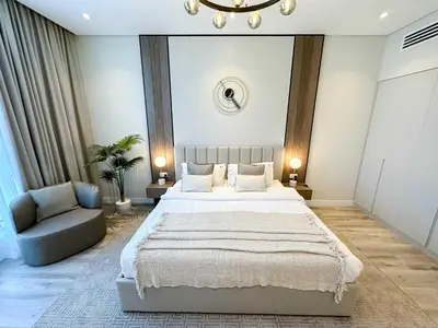a bedroom with a large bed and a chair at Sunset view apartment in Oceana in Dubai