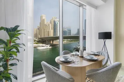 a dining room with a table and chairs and a large window at GuestReady - Contemporary with Ain Dubai View in Dubai