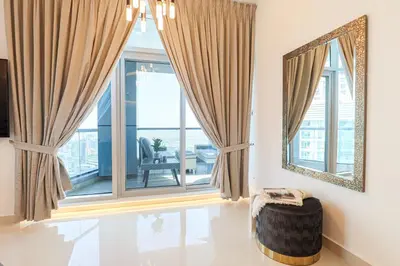 a living room with a large window and a mirror at HiGuests - Luxurious High-Rise Apartment With Stunning Views in Dubai