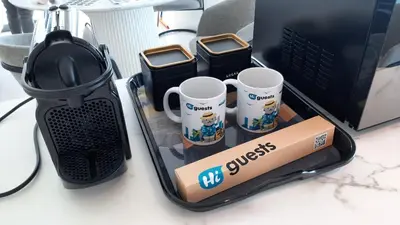 a desk with coffee cups and a laptop computer at HiGuests - Luxurious High-Rise Apartment With Stunning Views in Dubai