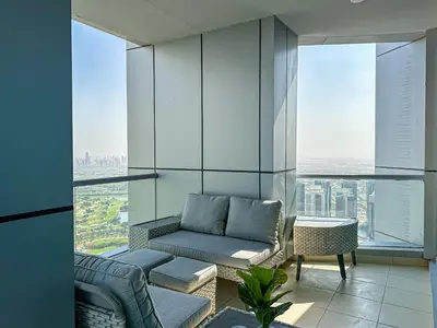 a living room with a couch and some windows at HiGuests - Luxurious High-Rise Apartment With Stunning Views in Dubai