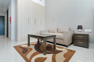 a living room with a table and a couch at Spacious Studio I Close to Dubai Canal in Dubai