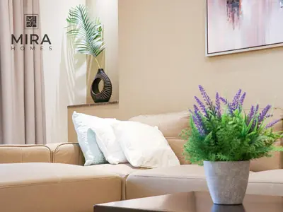 a living room with a couch and a vase with purple flowers at Mira Holiday Homes - Furnished 1 bedroom in Heart of Dubai in Dubai