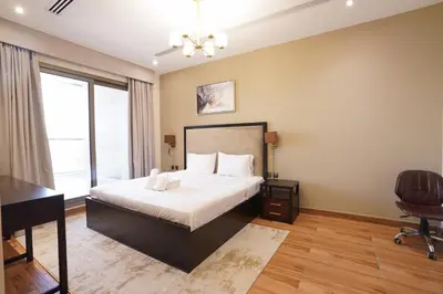 a bedroom with a bed and a desk and a chair at Mira Holiday Homes - Furnished 1 bedroom in Heart of Dubai in Dubai