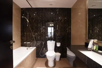 a bathroom with a toilet and a tub and a sink at Mira Holiday Homes - Furnished 1 bedroom in Heart of Dubai in Dubai
