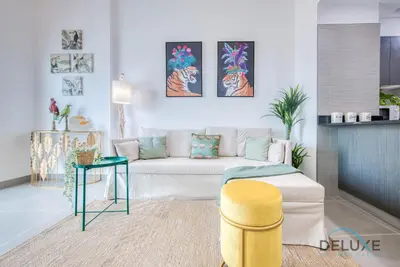 a living room with a couch and a table at Vibrant 1BR in Bella Rose Al Barsha South by Deluxe Holiday Homes in Dubai