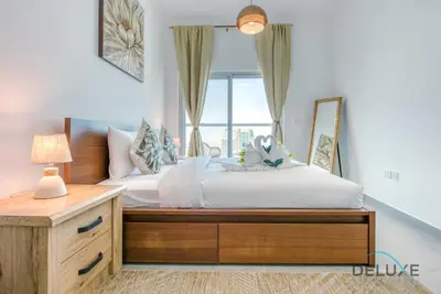 a bedroom with a bed with a mirror and a window at Vibrant 1BR in Bella Rose Al Barsha South by Deluxe Holiday Homes in Dubai