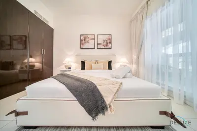 a white bedroom with a large bed and a window at Harmonious 1BR at Al Shera Tower JLT by Deluxe Holiday Homes in Dubai