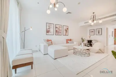a white living room with white furniture and a table at Harmonious 1BR at Al Shera Tower JLT by Deluxe Holiday Homes in Dubai