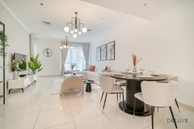 a dining room and living room with a table and chairs at Harmonious 1BR at Al Shera Tower JLT by Deluxe Holiday Homes in Dubai
