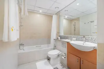 a bathroom with a sink and a toilet and a bath tub at Vogue The Greens Al Sidir near Mall of The Emirates, Three Bedroom Apartment with Balcony and full access to all amenities in Dubai