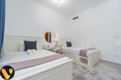 a bedroom with two beds and a mirror at Vogue The Greens Al Sidir near Mall of The Emirates, Three Bedroom Apartment with Balcony and full access to all amenities in Dubai