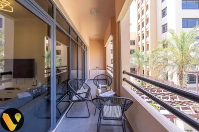 a balcony with chairs and a tv on a building at Vogue The Greens Al Sidir near Mall of The Emirates, Three Bedroom Apartment with Balcony and full access to all amenities in Dubai