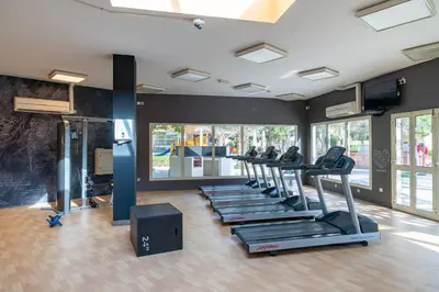 a gym with a row of treadles in a room at Vogue The Greens Al Sidir near Mall of The Emirates, Three Bedroom Apartment with Balcony and full access to all amenities in Dubai