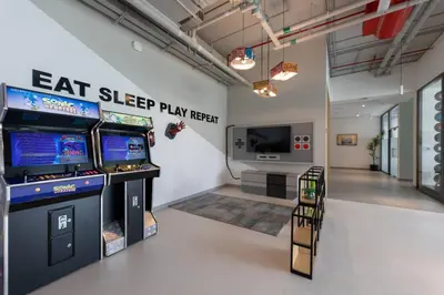 a room with two arcade games and a television at BNew Chic 1BR Apt Near Trump Golf w Pool and Gym in Dubai
