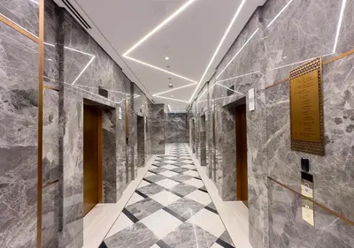 a hallway with marble walls and a checkered floor at Stunning 1BR in Stella Maris, City View, Marina in Dubai