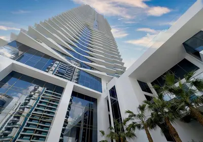 a tall building with palm trees in front of it at Stunning 1BR in Stella Maris, City View, Marina in Dubai