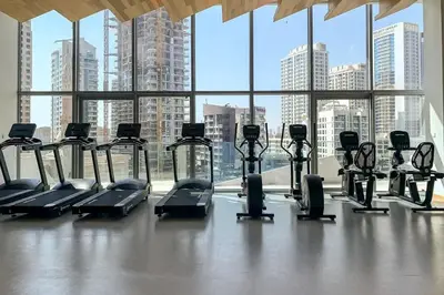 a gym with cardio equipment in front of a large window at Frank Porter - Stella Maris in Dubai