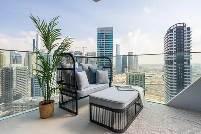 a balcony with a chair and a plant on a city skyline at Frank Porter - Stella Maris in Dubai