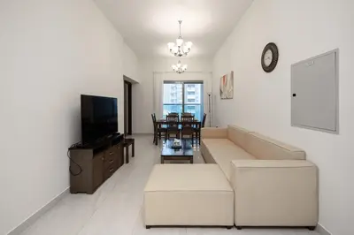 a living room with a couch and a tv at Stylish 4BR with Jacuzzi, Sauna & Prime Amenities in Dubai