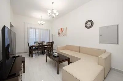 a living room with a couch and a table at Stylish 4BR with Jacuzzi, Sauna & Prime Amenities in Dubai