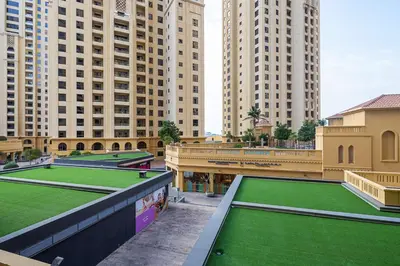 a group of tennis courts in a city with tall buildings at Frank Porter - Rimal 1 in Dubai