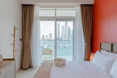 a bedroom with a bed and a large window at Private Beachfront 1 Bed With 180 view of Marina Skyline in Dubai