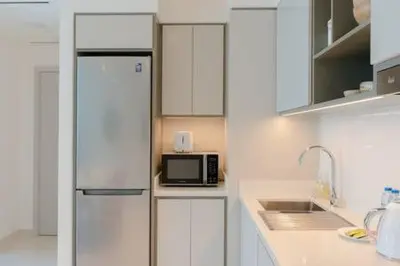 a kitchen with white cabinets and a microwave at Private Beachfront 1 Bed With 180 view of Marina Skyline in Dubai