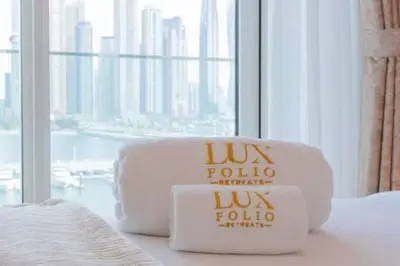two towels sitting on a bed in a hotel room at Private Beachfront 1 Bed With 180 view of Marina Skyline in Dubai