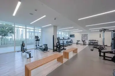 a gym with benches and exercise equipment in a room at Private Beachfront 1 Bed With 180 view of Marina Skyline in Dubai