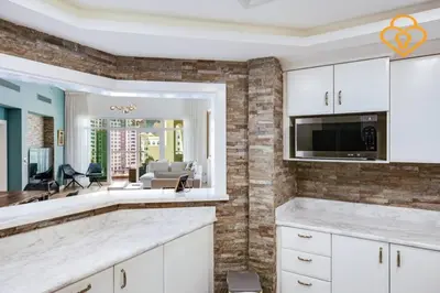 a kitchen with white cabinets and a brick wall at Keysplease Upgraded 3 B/R + Nanny Beach Access, Palm Jumeirah in Dubai